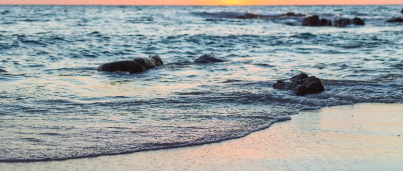 Закат на песчаном пляже с волнами