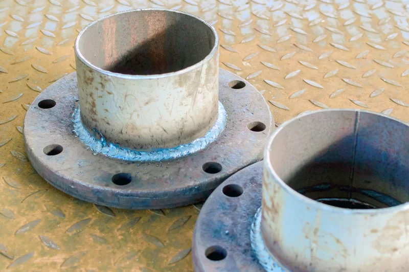 Детали трубопровода: фланцы и сварные соединения на металлической поверхности