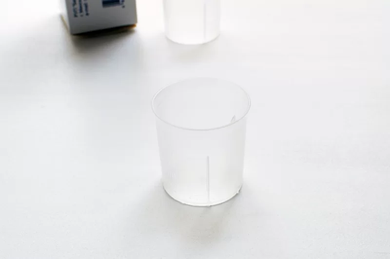 Пустые мерные стаканчики на белом фоне