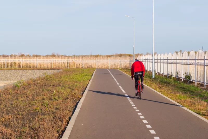 Человек в красной куртке на велосипеде
