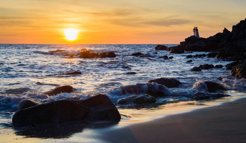 Закат над морем с парой на скалах