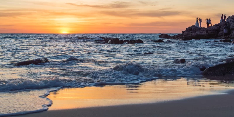 Закат над океаном с силуэтами влюбленной пары