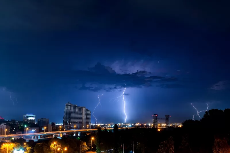 Гром, молнии и шторм в темном ночном небе над городом
