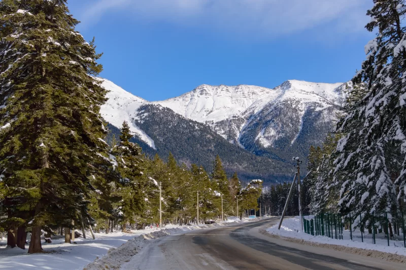 Зимняя дорога в заснеженных горах