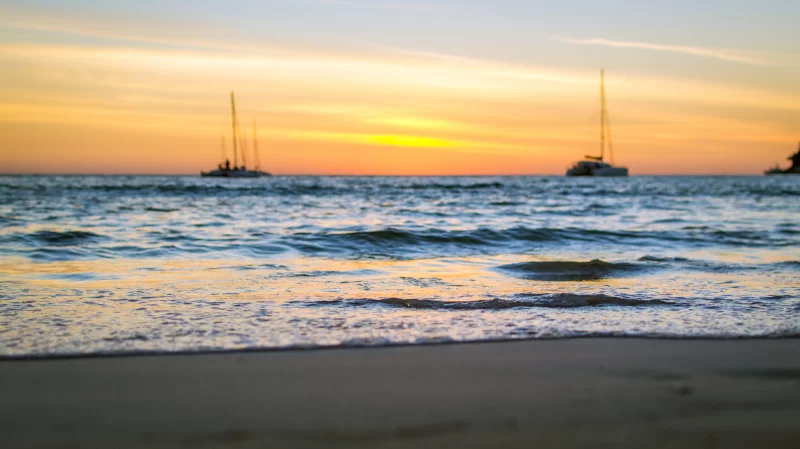 Закат на пляже с парусниками