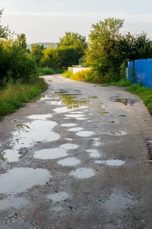 Порченная дорога деревни после дождя