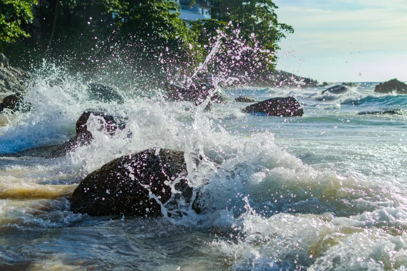 Мощные волны океана, разбивающиеся на скалистом берегу