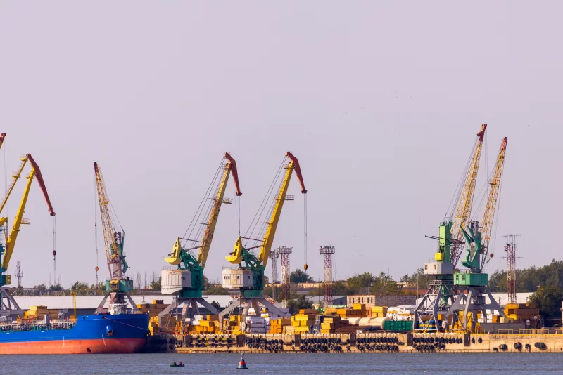 Industrial port cranes against hazy sky