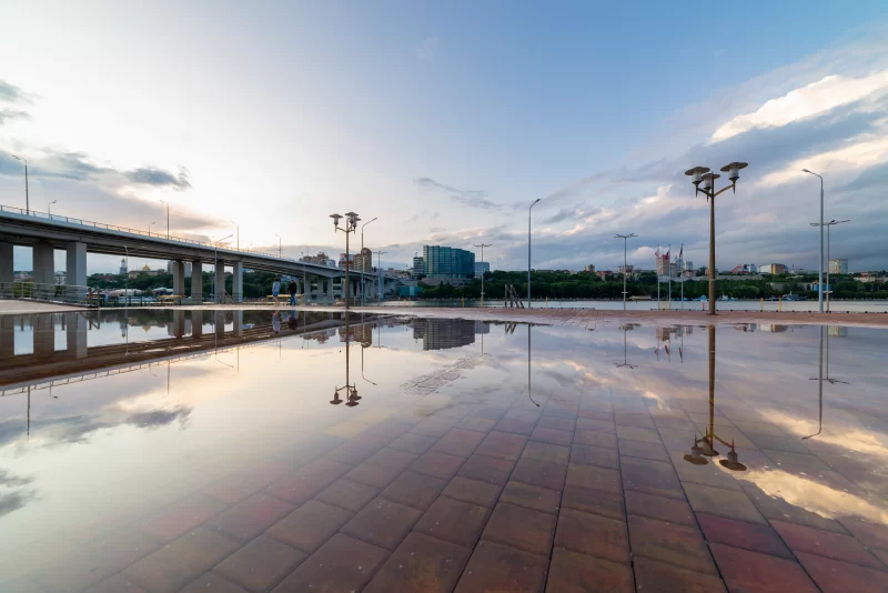 Reflection of urban bridge and sky in puddle