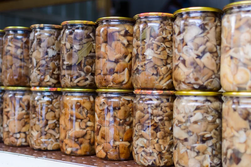 Банки с маринованными грибами, заготовленные на зиму, домашние консервы