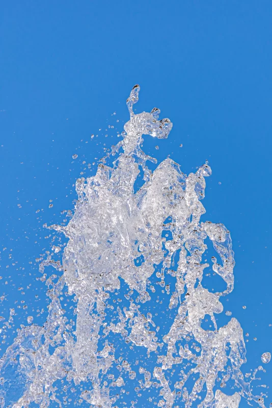 Динамичный водяной сальто на фоне ярко-синего неба