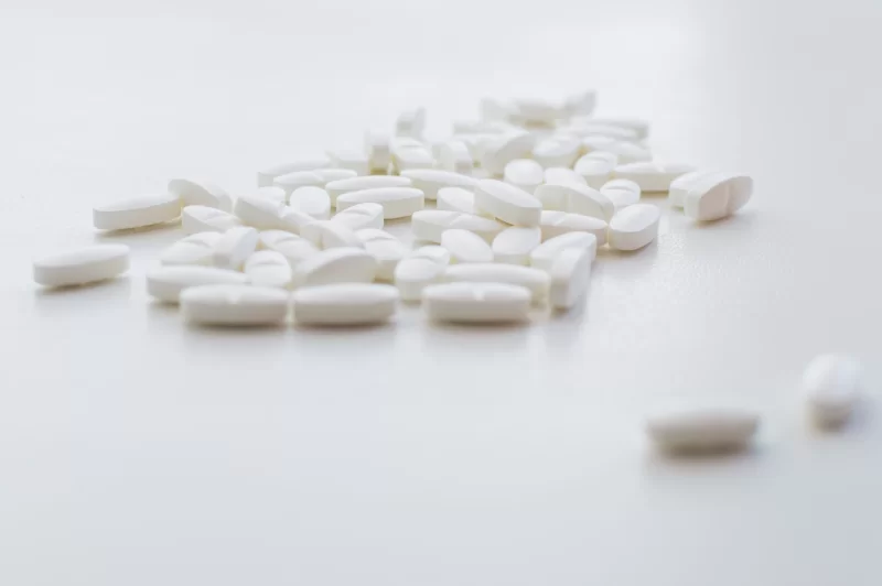 Белые таблетки на чистом белом фоне, крупный план