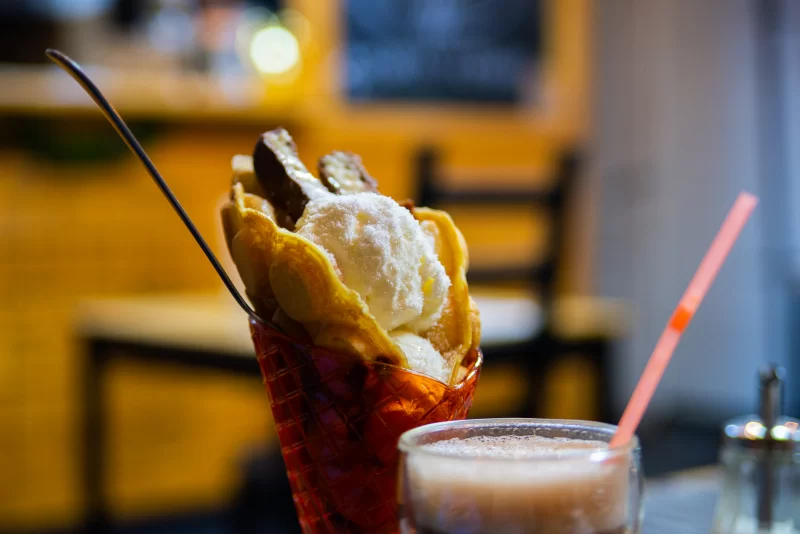 Аппетитный вафельный рожок с мороженым и шоколадом, и освежающий напиток