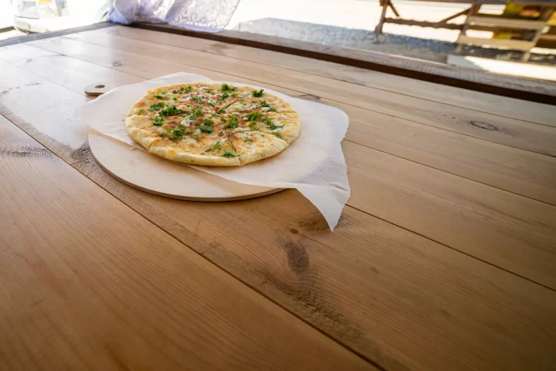 Аппетитный хачапури с зеленью на деревянном столе