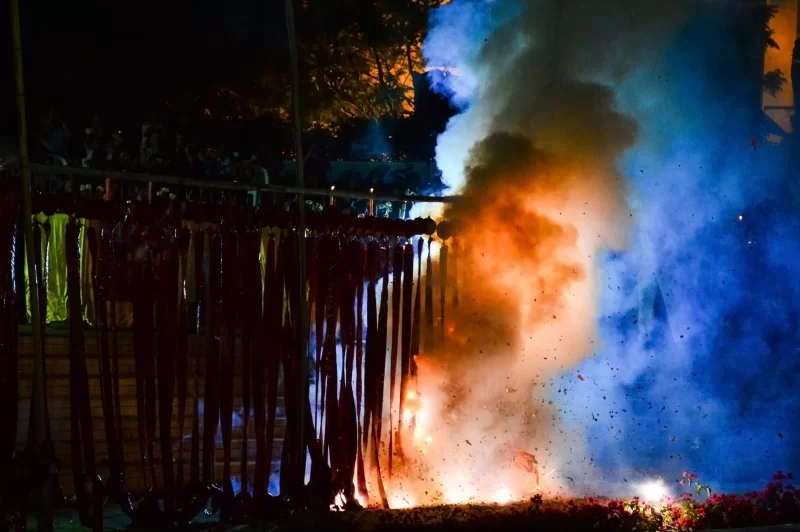 Ночная фейерверк-эксплозия с огненными и синими облаками дыма