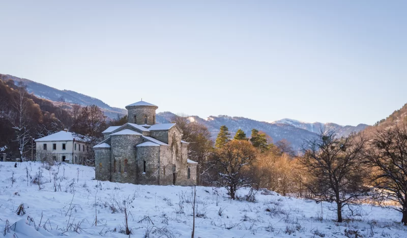 Зимний пейзаж с древним храмом и горной долиной