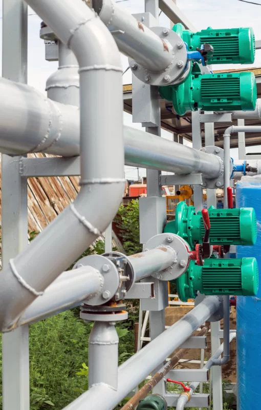 Промышленная насосная система с зелеными насосами и серыми трубами