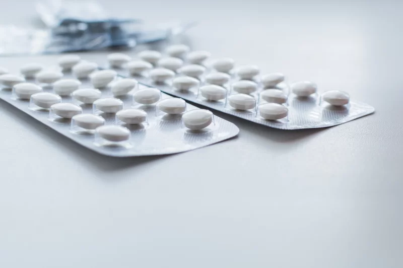 Blister packs with white pills on a light surface