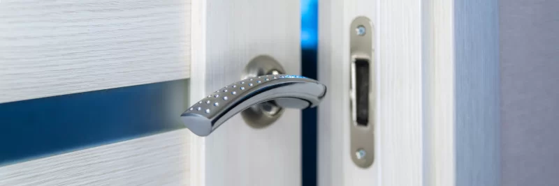 Современная дверная ручка с элегантным дизайном на фоне светлой двери