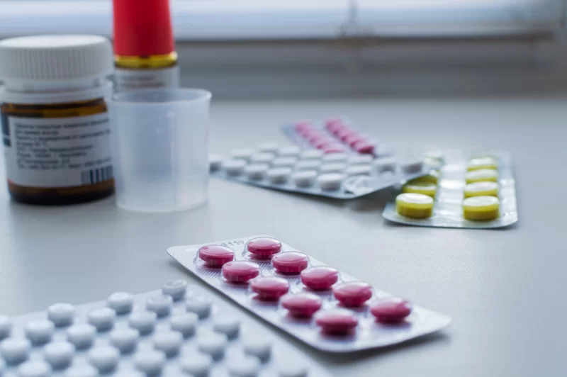 Различные лекарства и таблетки в блистерах на столе