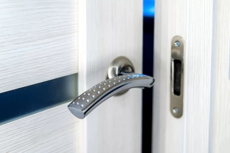 Современная дверная ручка с LED-подсветкой на белой двери