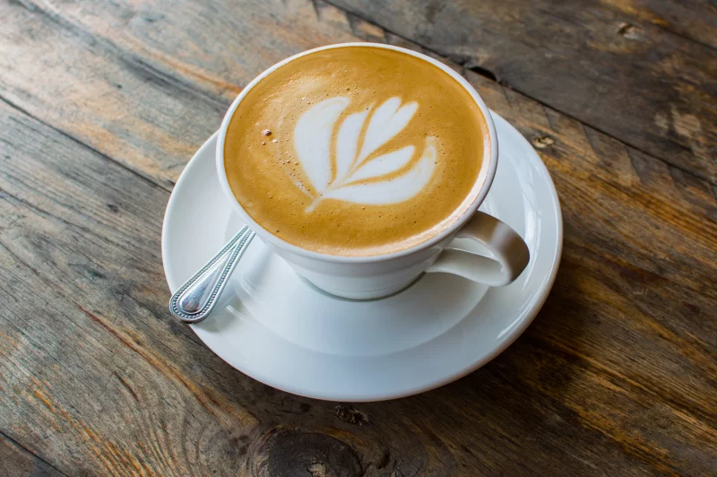 Элегантный капучино с латте-артом на деревянном столе