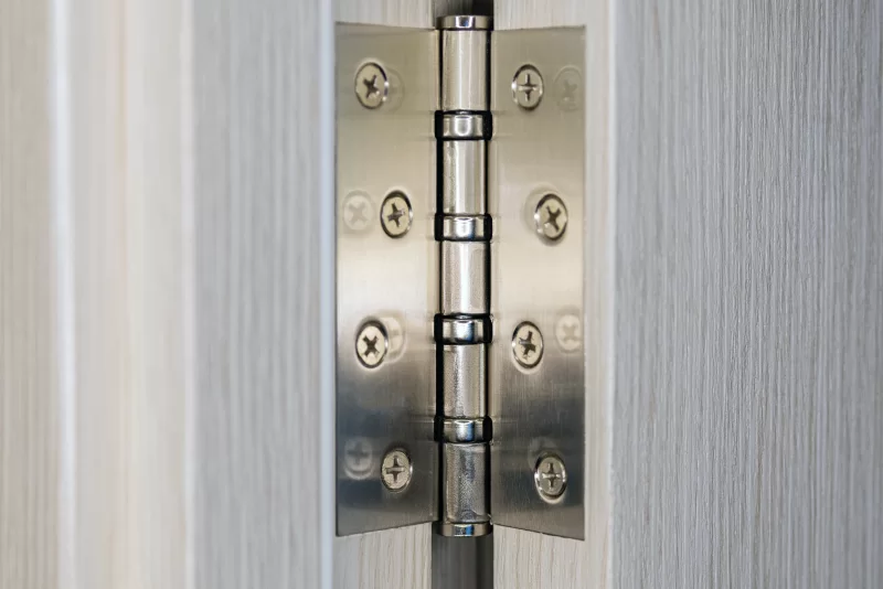 Детальный макросъемка металлической петли на двери с текстурой дерева