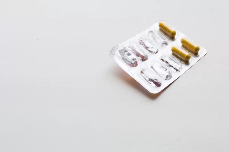 Упаковка капсул с лекарством, оставшиеся таблетки на блестящей фольге