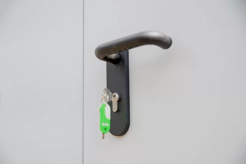 Ключи на ручке двери с зелёным брелком