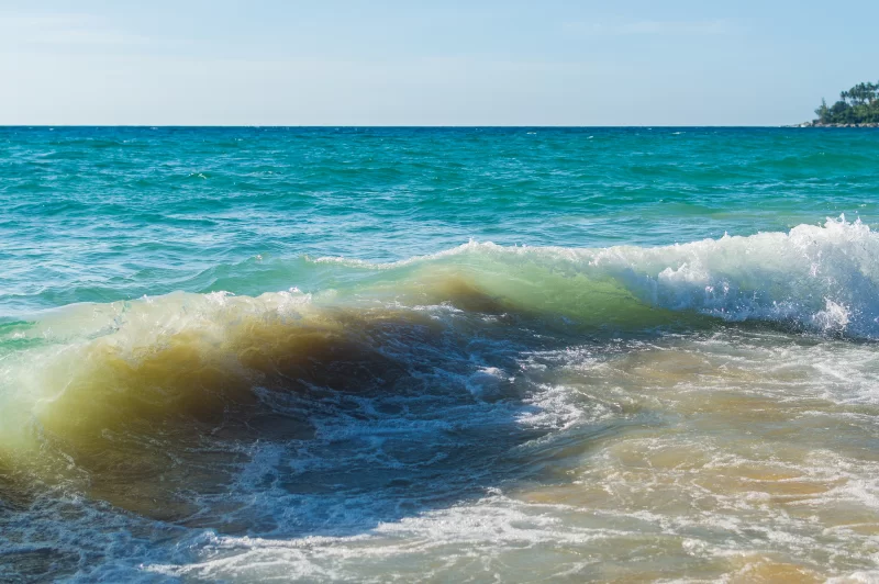 Мощные волны океана разбиваются на песчаном пляже