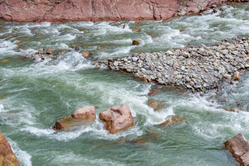 Динамичная горная река с бурными порогами и живописными скалами