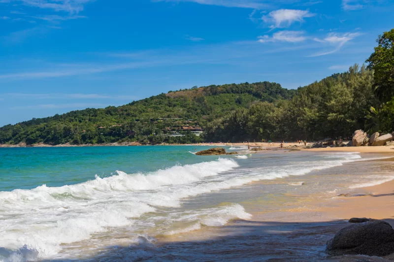 Тропический пляж с прозрачным морем и зелеными холмами