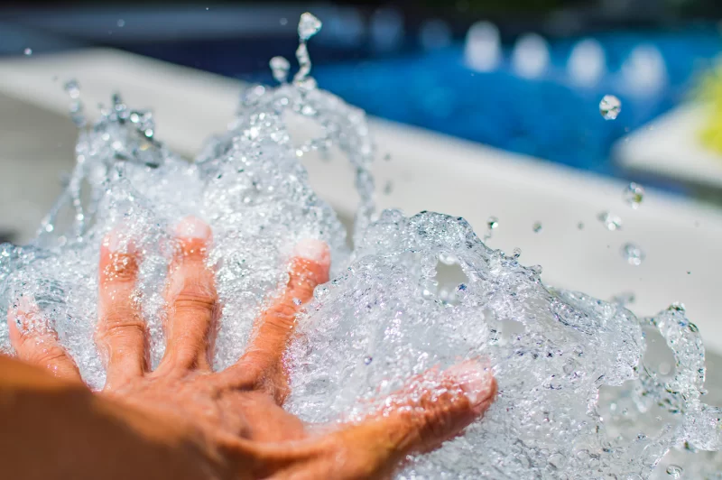 Hand splashing water in pool