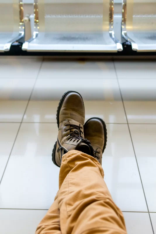 Ожидание в аэропорту: ноги в походных ботинках на плитке
