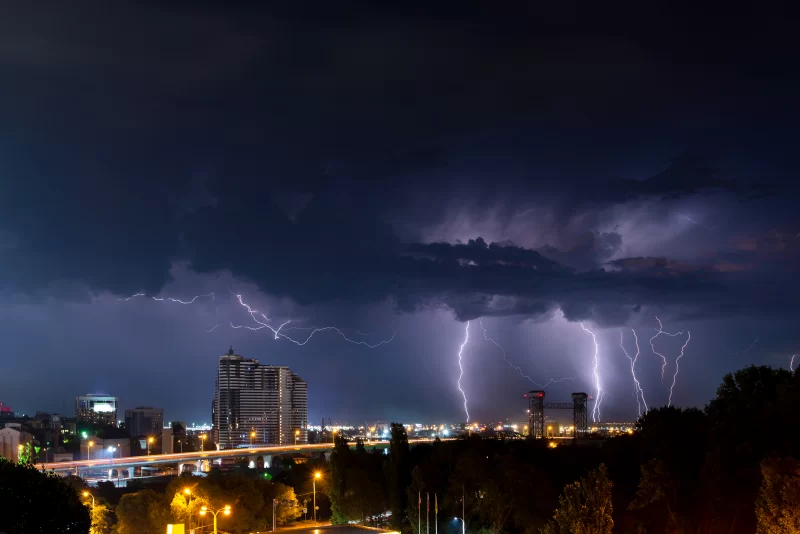 Гром, молнии и шторм в темном ночном небе над городом