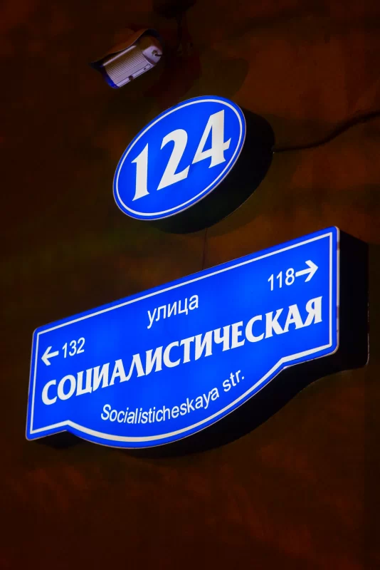 Bright night light of street sign with house number 124 and Socialistheskaya street name