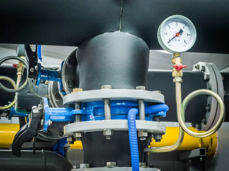 Детали промышленной системы: трубы, манометр и вентиль