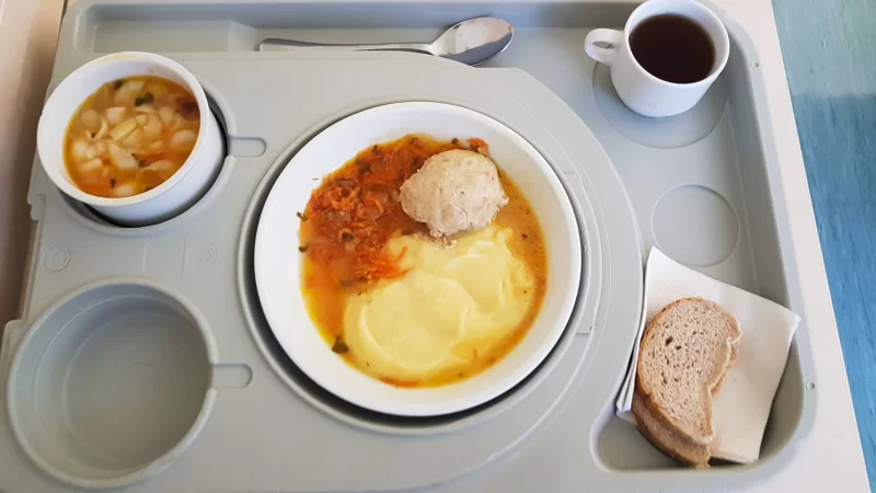 Сытный обед на подносе: мясная котлета с пюре, суп и чай