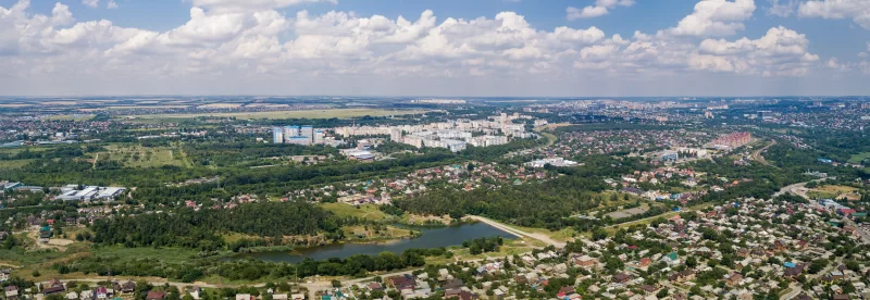 Панорамный вид на город с высоты птичьего полета: сочетание природы и городской застройки