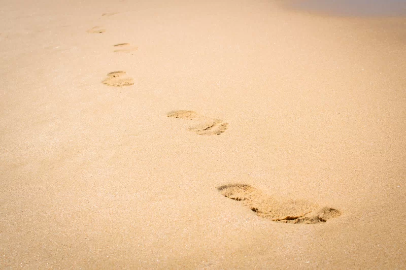 Следы ног на песке у моря
