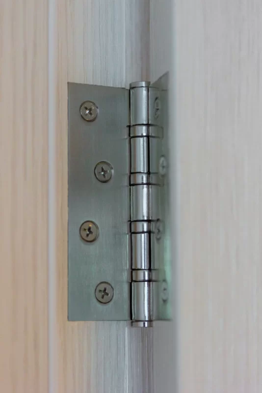 Металлическая петля двери на светлом деревянном фоне