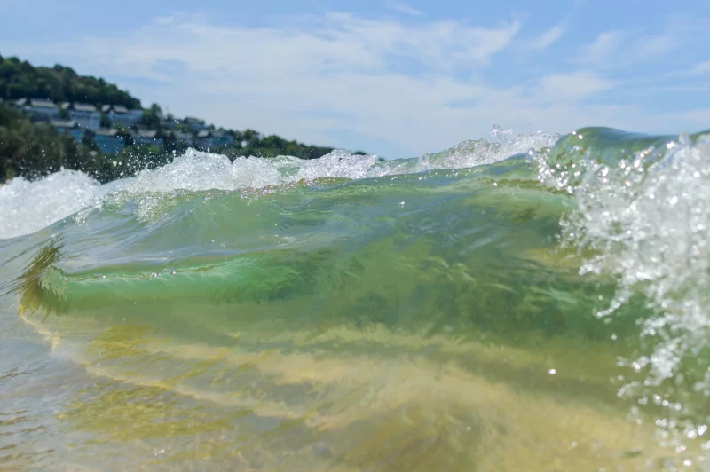 Близкий план морской волны с зеленоватой водой и белой пеной