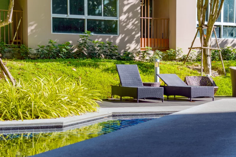 Лежаки у бассейна в солнечном саду