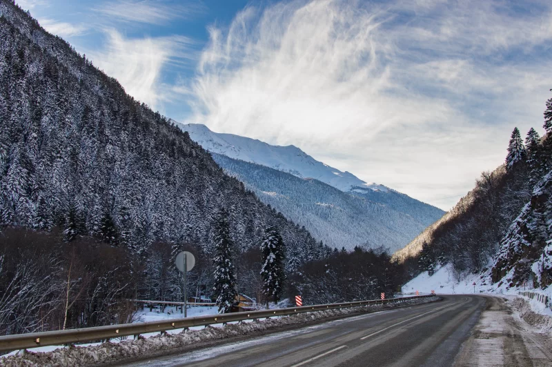 Зимняя дорога в заснеженных горах