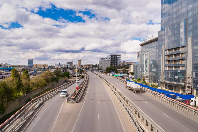 Urban highway with modern skyscrapers and cloudy sky