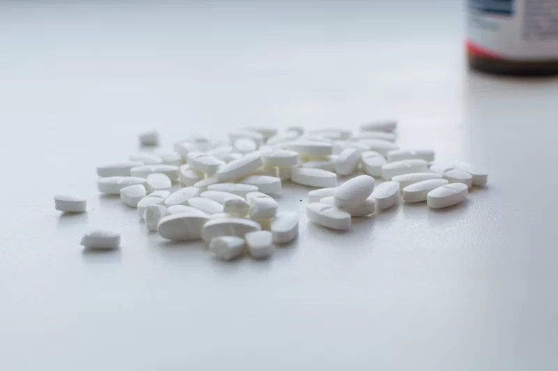 Куча белых таблеток на белом фоне