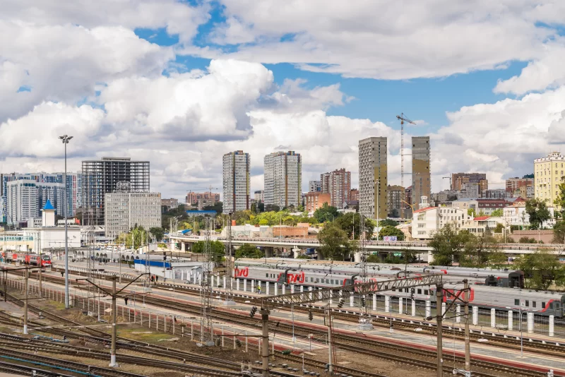 Городской железнодорожный вокзал с поездами и современной архитектурой