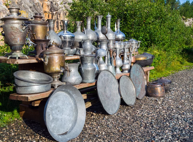 Старинные металлические котлы и посуда на деревянной тележке в природе