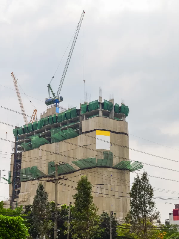 Строительная площадка с кранами и высотным зданием