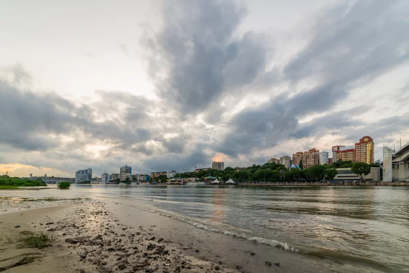 Городской пейзаж реки с драматичным небом